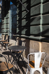 Stone street cafe - metal chairs, tables. Sunny day.