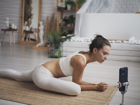 
Young Woman Is Engaged Online At Home On A Computer. Online Workouts, Yoga, Stretching And Incense