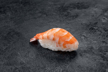 One nigiri sushi with prawn on a stone dark background. Japanese dish sushi ebi