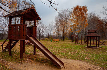 Fototapeta na wymiar Wooden slides on the playground in autumn