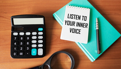 LISTEN TO YOUR INNER VOICE - inspirational text on notepad with calculator, magnifier, weekly,...