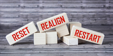reset, realign, restart concept - abstract words written on wooden blocks