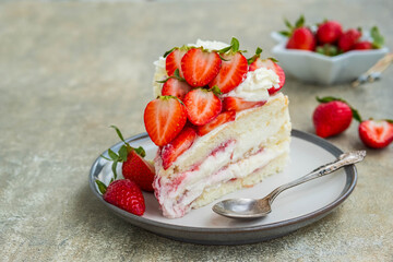 Dessert, sliced sponge cake with custard, fresh strawberries and whipped cream on a gray concrete background. Swedish cuisine.