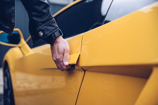 Man Is Reaching For The Car Door Handle. Car Rental Or Car Theft Concept