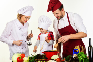 Healthy food at home. Happy family in kitchen preparing dinner. Son with parents cooking.