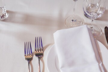 tableware Glasses, flower fork, knife served for dinner in restaurant with cozy interior