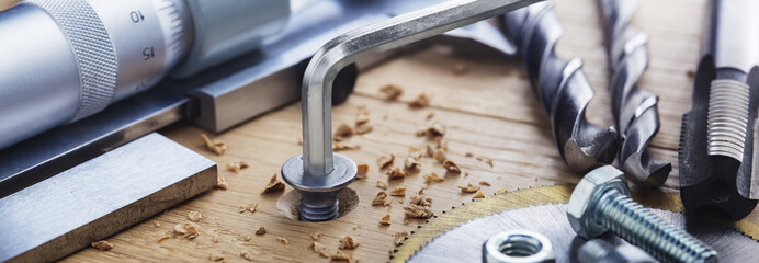 hex bolt screw by hex wrench in wooden oaks plate with with vernier caliper and ruler