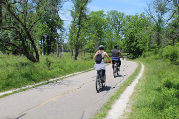 Man and woman riding bikes on the North Branch Trail at Miami Woods in Morton Grove, Illinois