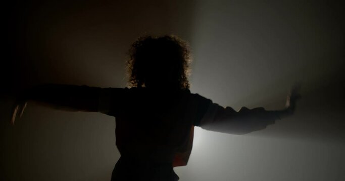Curly girl silhouette dancing
