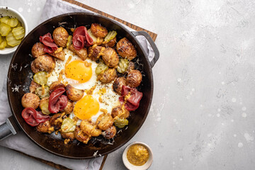 Potato hash with fried eggs and meat pastrami for breakfast branch