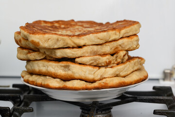 a plate of thick white flour tortillas on a plate.