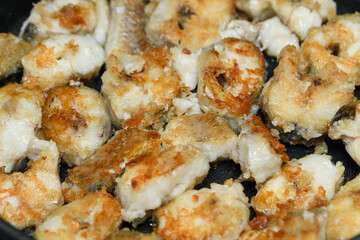 fried pieces of fish in a frying pan. Homemade food