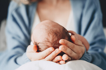 Newborn in mother's hands. Baby care. Childbirth and motherhood concept.