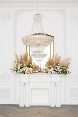 beautiful classical white interior with a fireplace, a vintage chandelier. Retro, classics