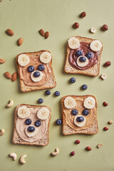 Funny children bear toasts with nuts butters for breakfast