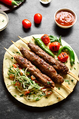 Adana Kebab with fresh vegetables on flatbread