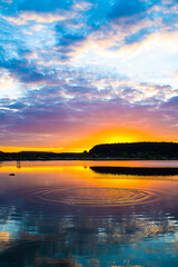 Obraz premium sunset at coast of the lake. Nature landscape. reflection, blue sky and yellow sunlight. landscape during sunset.