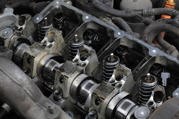 Fototapeta premium Detail of modern diesel engine repair, closeup of injectors in cylinder head with camshaft, selective focus