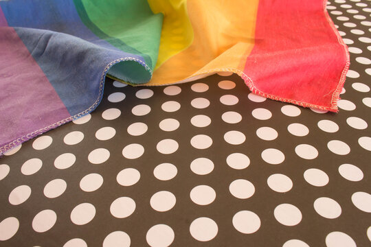 Flag with the colors of the rainbow on a polka dot background.