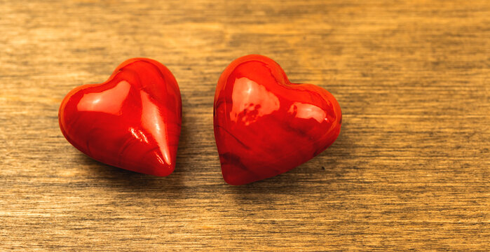 Two red hearts on a wooden table background, macro photo close-up