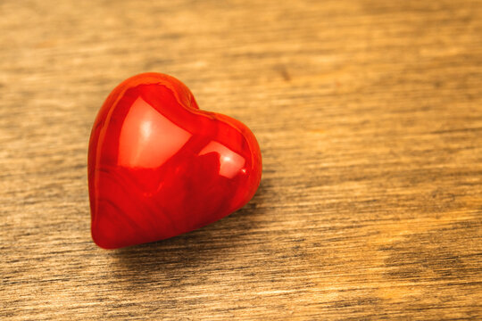 Red heart on a wooden table background close-up photo, concept of love