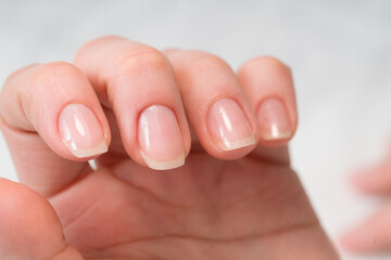 Woman in a nail salon receiving a manicure by a beautician with nail file. Beauty and hand care close-up.
