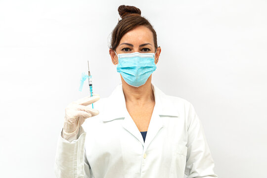 Enfermeira na frente com uma cara feliz e aliviada, com uma seringa entre os dedos, luva cirúrgica e jaleco, no fundo branco