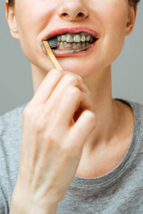 Woman with healthy white teeth holds a toothbrush and smiles. Oral hygiene concept