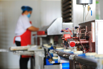 Workers on the moon cake production line work hard in the food processing plant