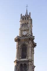 Valenciennes, France, 2017-01-06. The steeple (tower) with a bell and a clock and a cross and rooster on the top. Gothic church of Saint Gery (Gaugericus).