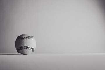 Baseball nostalgia with vintage background behind old used ball from sport game in black and white.