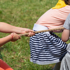 Children are playing, pulling a rope.