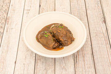 serving of pork cheeks in sauce with chives on top