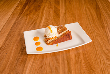 portion of carrot cake accompanied by a scoop of vanilla ice cream