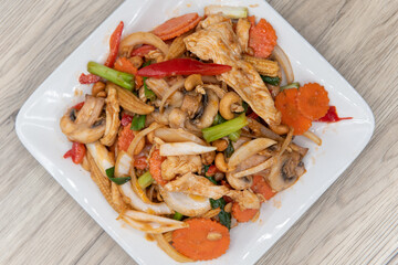 Overhead view of spicy stir fry of cashew nuts, chicken, baby corn, and carrots for a perfect blend of flavor explosion