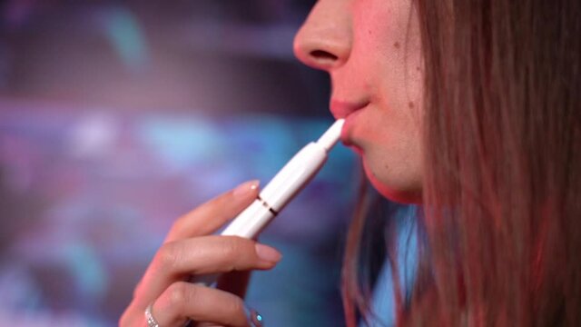 Cigarette. The woman smokes an electronic cigarette. Close-up.