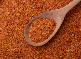 Top view, closeup of cayene pepper on a spoon. Food backdrop