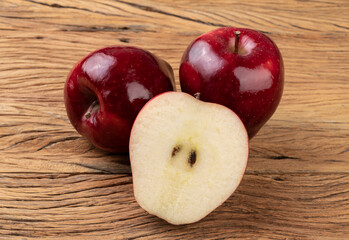 Red apples and half fruit over wooden table