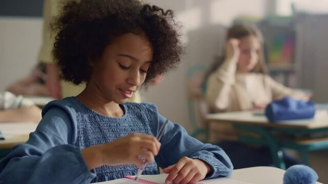 Girl raising hand at lesson. Female teacher helping student with class work