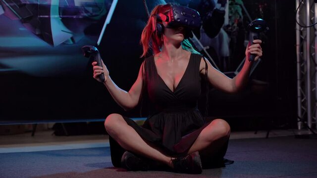 Virtual reality. A woman plays games in a virtual reality helmet.
