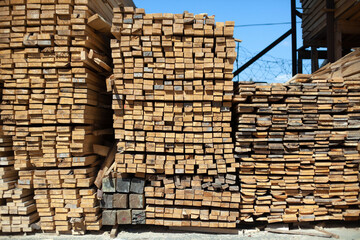Lots of boards in the warehouse. Bars of wood are stacked.