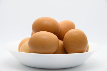 White plate with brown eggs