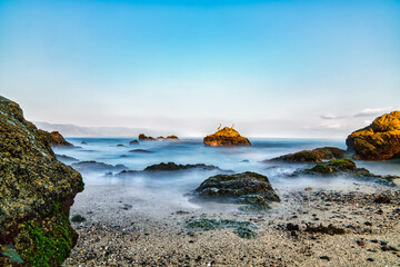 Puerto Vallarta beach on a long exposure with 3 pelicans standing in a rock