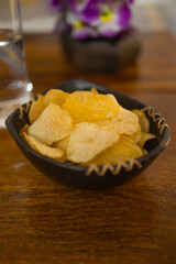 A bowl full of freshly fried golden crispy color potato chips
