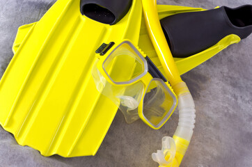 snorkel mask and fins on gray