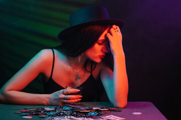 girl lost in the casino at the table with chips and cards