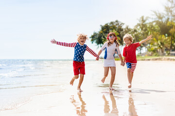 Kids with American flag on beach. 4th of July.