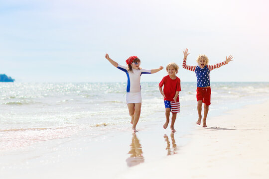 Kids with American flag on beach. 4th of July.