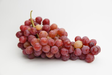 Fresh and ripe red grapes isolated in white background. Bunch of raw and juicy grapevines