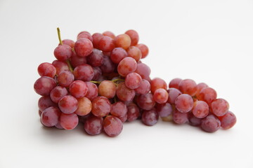 Fresh and ripe red grapes isolated in white background. Bunch of raw and juicy grapevines